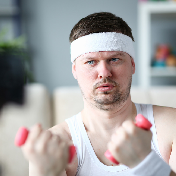 Harry Smith wearing headband and holding dumbbells